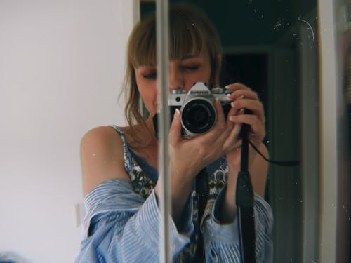 Young Woman Taking a Picture in a Mirror 