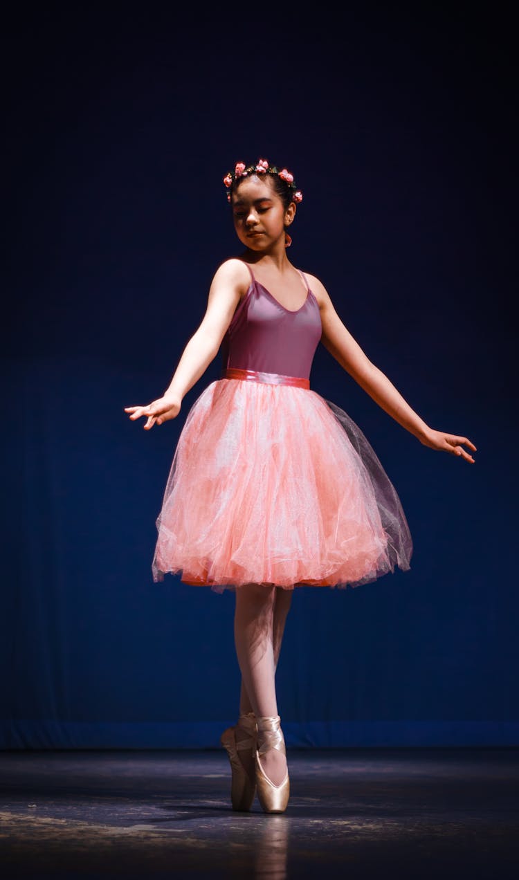 Young Ballerina In A Pink Dress Dancing On Stage