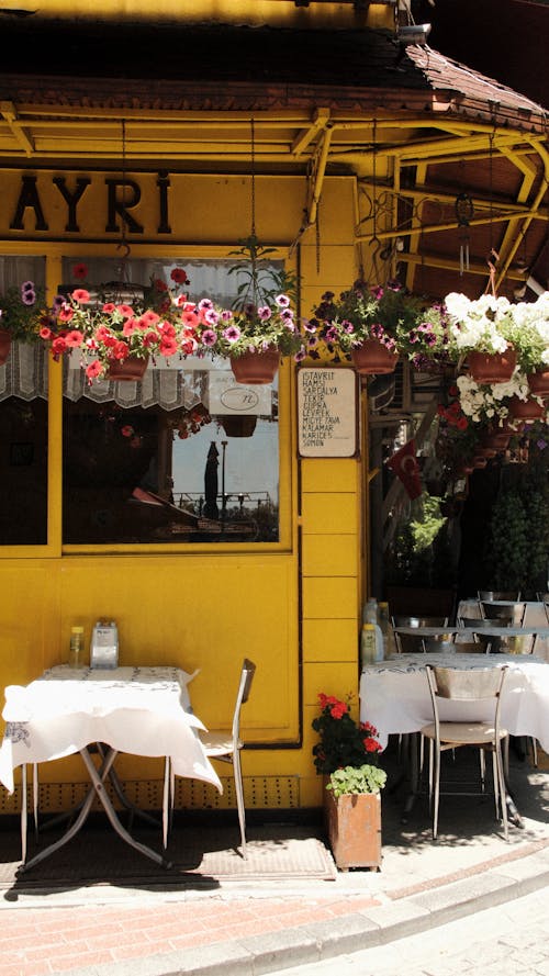 A Small Cafe Decorated with Flowers on the Outside 