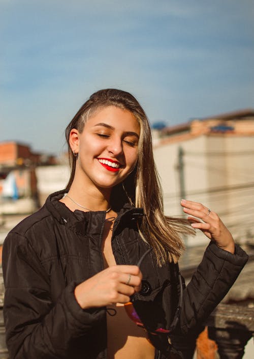 Smiling Young Woman Posing against Blue Sky