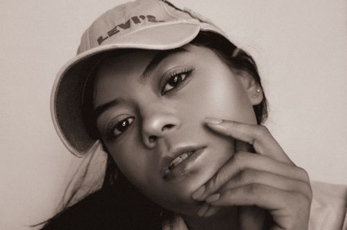 Free Close-up monochrome portrait of a woman wearing a cap, looking contemplative. Stock Photo