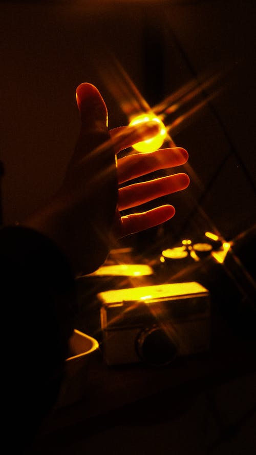 Close-up of Person Hand in Light on Black Background