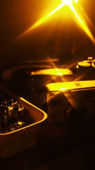 A nostalgic setup with vintage camera and films illuminated by warm, soft light.