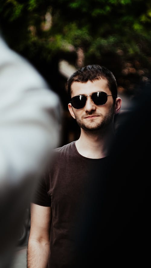 Young Man in Sunglasses Standing in the Crowd 