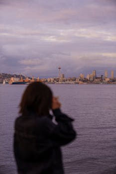 A scenic view of the Seattle skyline and Space Needle during a beautiful sunset over the water.