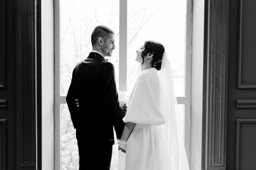 Free A romantic black and white photo of a newlywed couple holding hands, with a joyful expression. Stock Photo