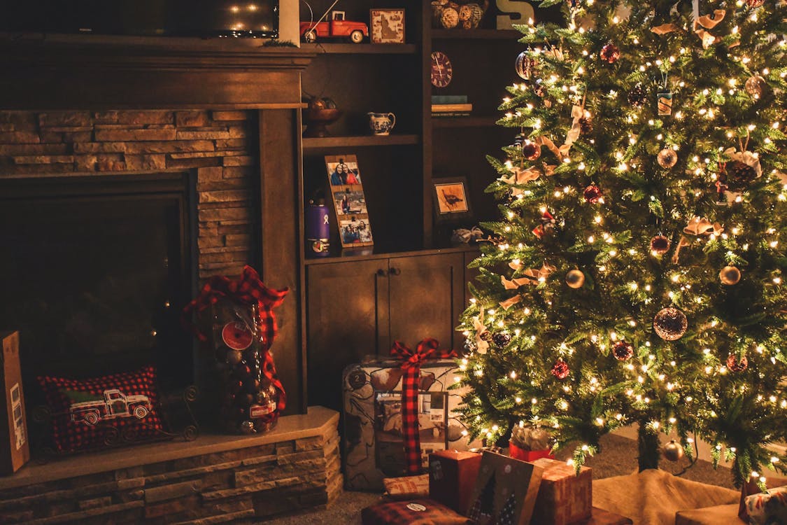 a decorated Christmas tree near a fireplace