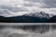 白雪皑皑的山脉壮丽地倒映在爱达荷州洛曼平静的湖水中