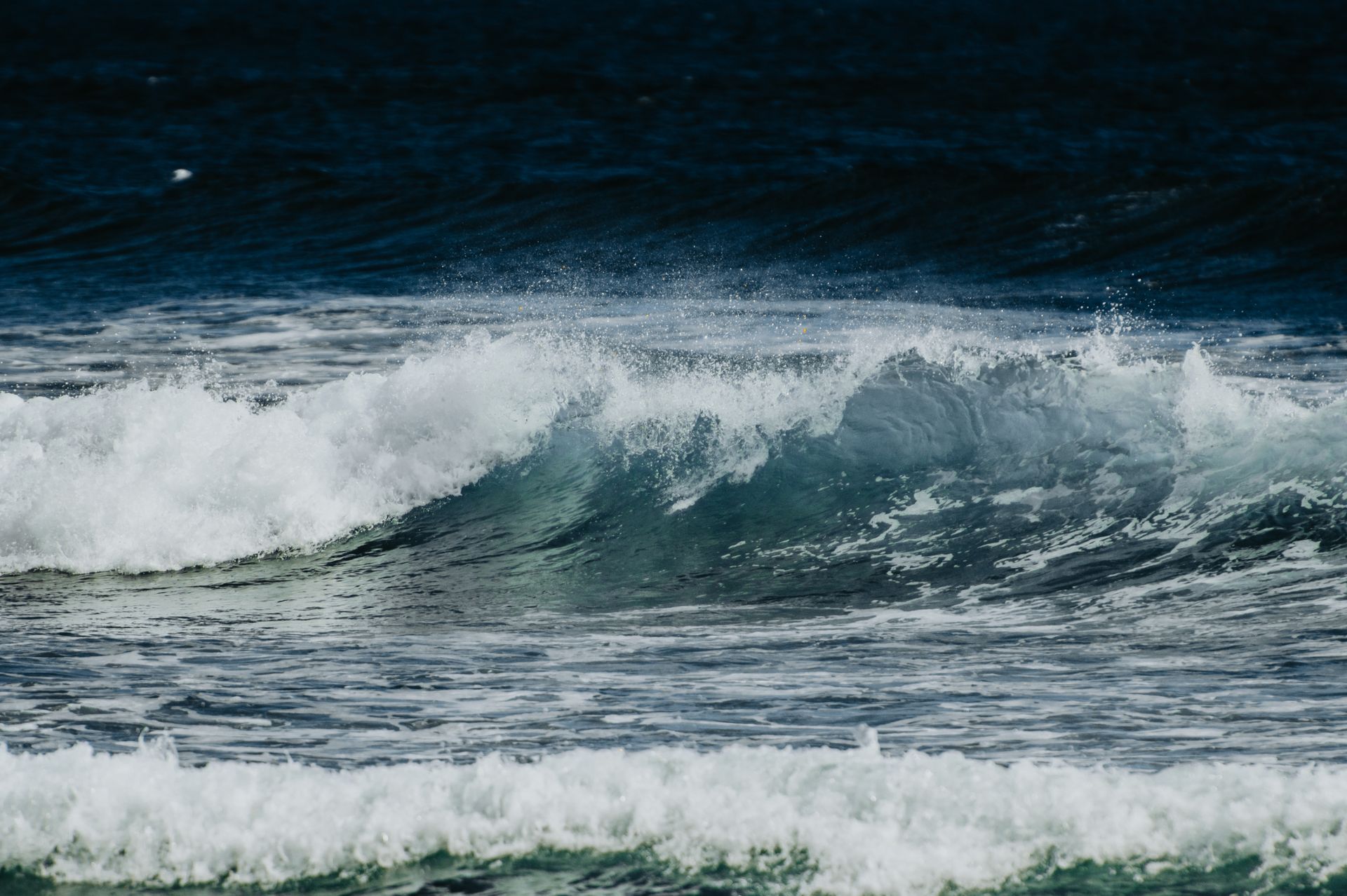 Captivating view of ocean waves crashing with splashes and foam on a windy day.