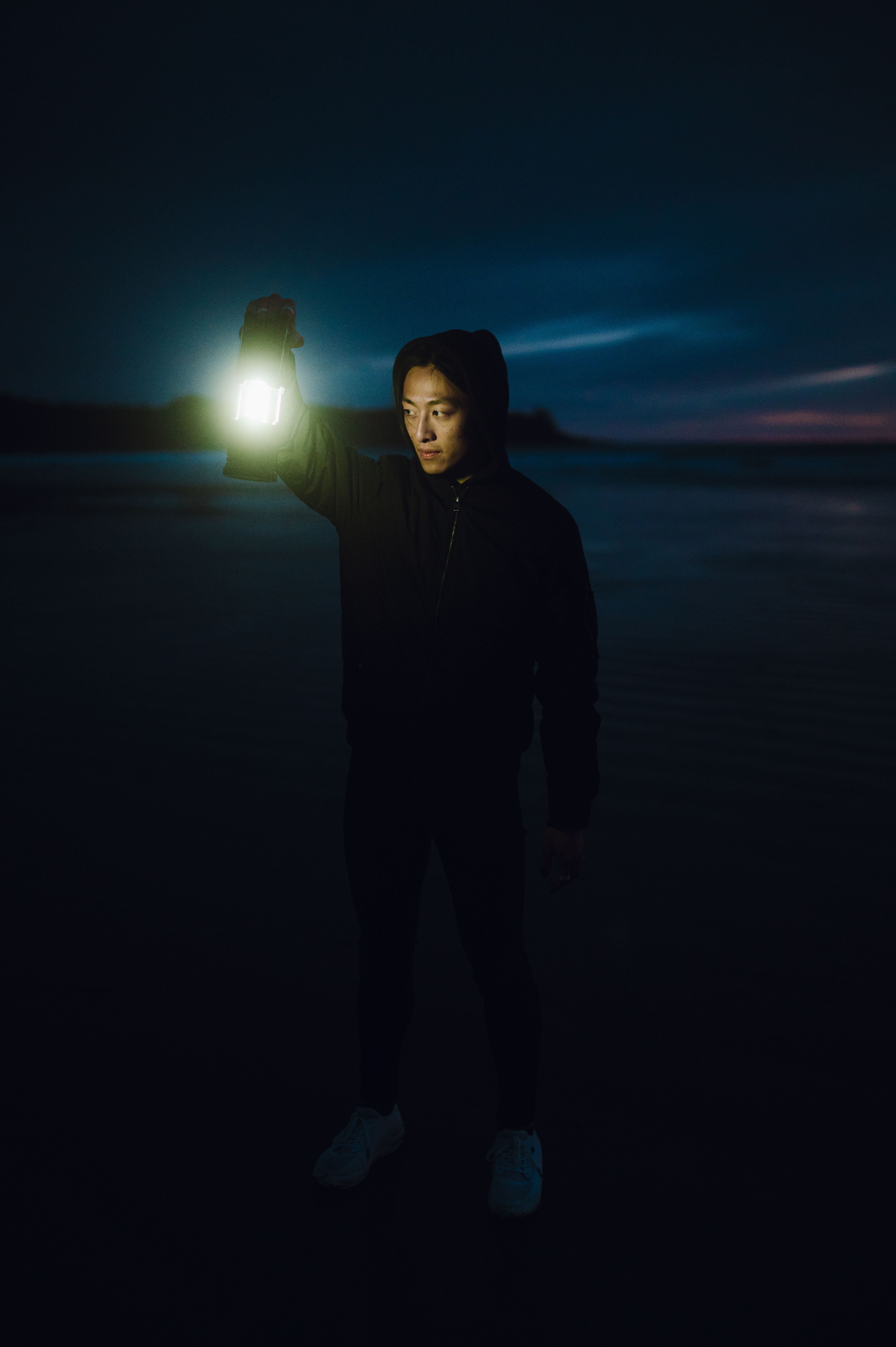 Young Man Holding a Lantern in the Dark · Free Stock Photo