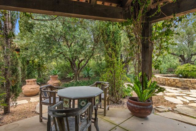 Terrasse ombragée du salon de thé nichée dans un jardin méditerranéen près de Périgueux