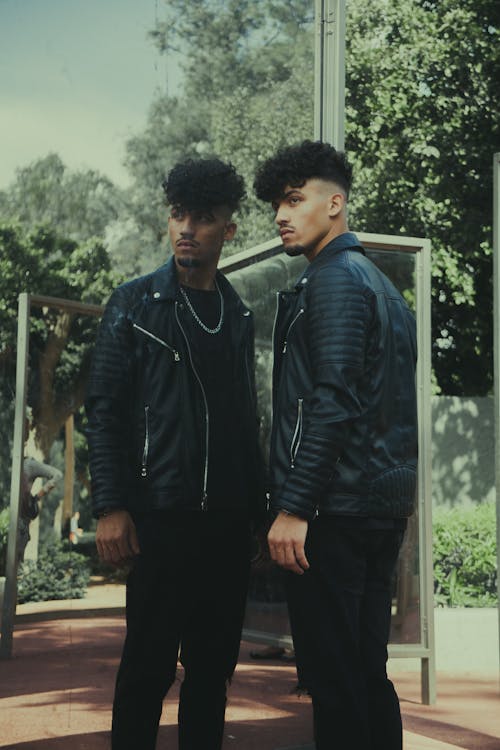 Young Man in a Leather Jacket and his Reflection in the Building Facade 