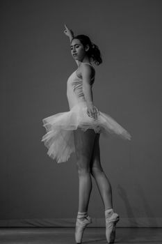 Black and white image of an elegant ballerina in motion, showcasing grace.