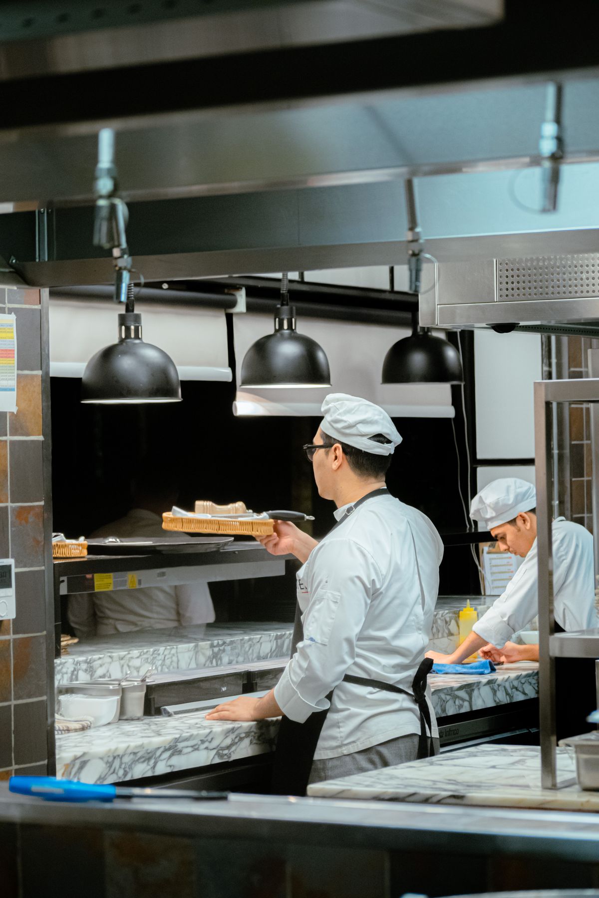 Two cooks working a service line at the pass