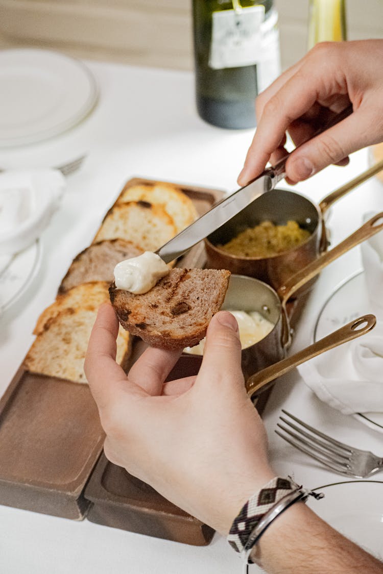 Close-up Of Man Spreading Butter On A Toast 