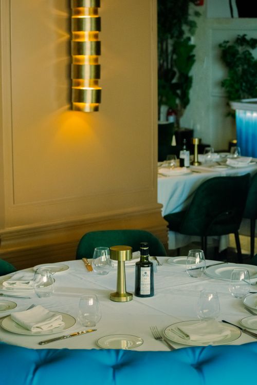 Free Sophisticated dining table setup in a stylish restaurant with contemporary lighting and decor. Stock Photo