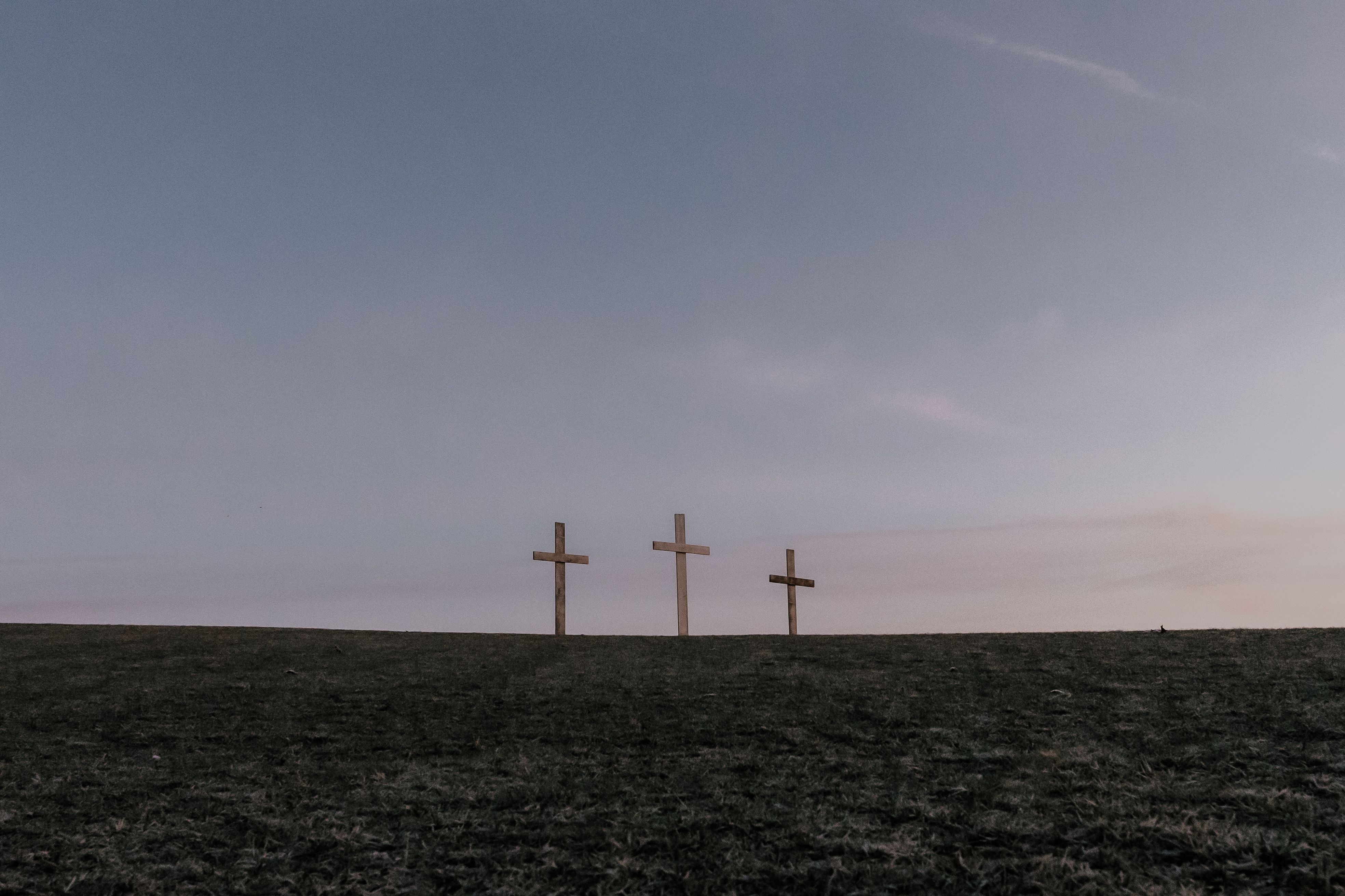 A serene image of three crosses on a hill at dusk, symbolizing faith and tranquility.