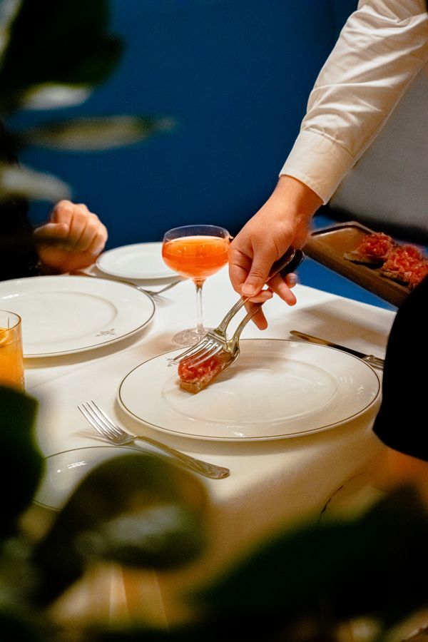 Server placing a gourmet plate before a guest