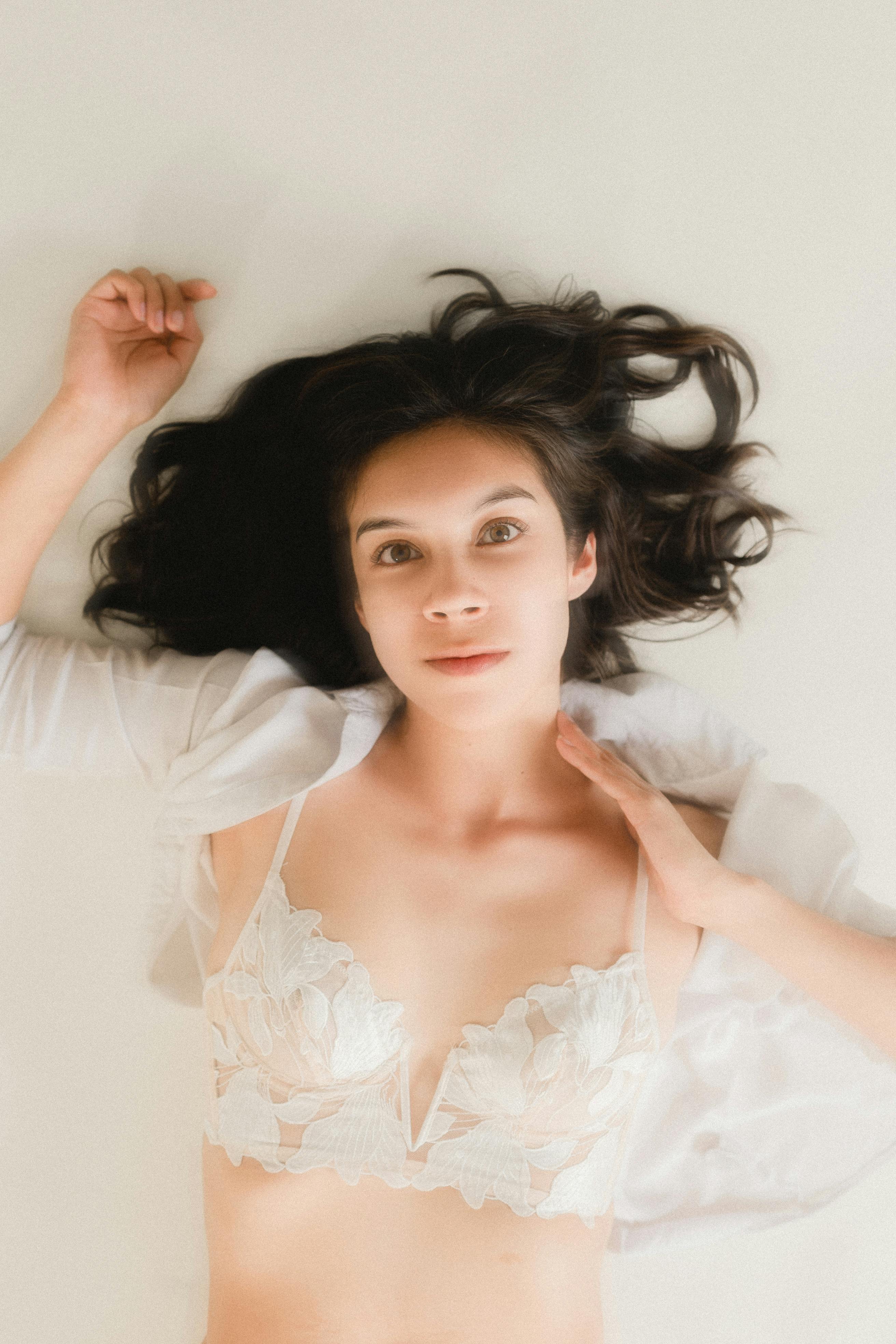 Sweet, Smiling Woman in Red Bra Lying on Couch Stock Photo