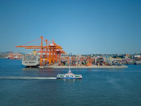 A scenic view of a bustling cargo port in Vancouver, BC, with cranes and containers.