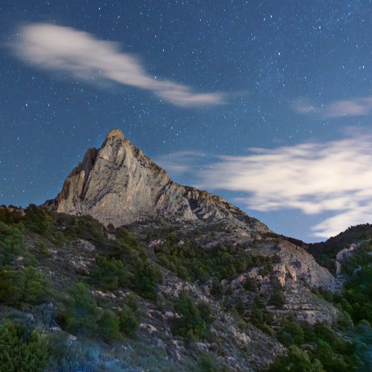 Clouds And Stars Over Mountain At Night