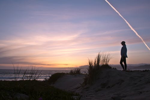 Free Photo of Person Standing On Sand During Dawn Stock Photo