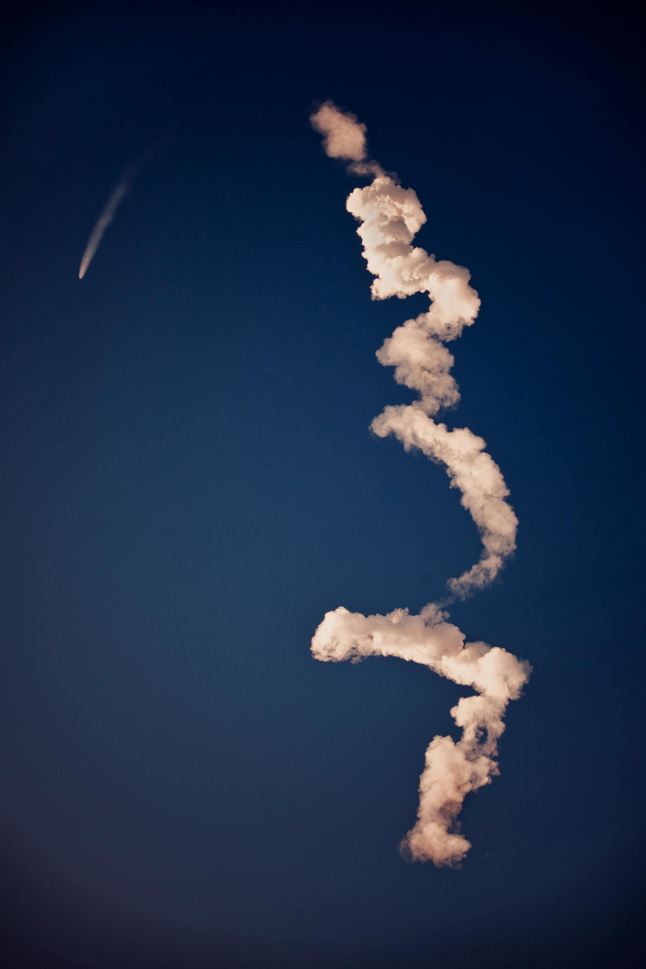 蜿蜒的轨迹映衬在充满活力的蓝天下，展现了航空技术的魅力