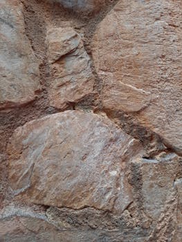 Detailed view of a rough, weathered stone wall showcasing natural textures.