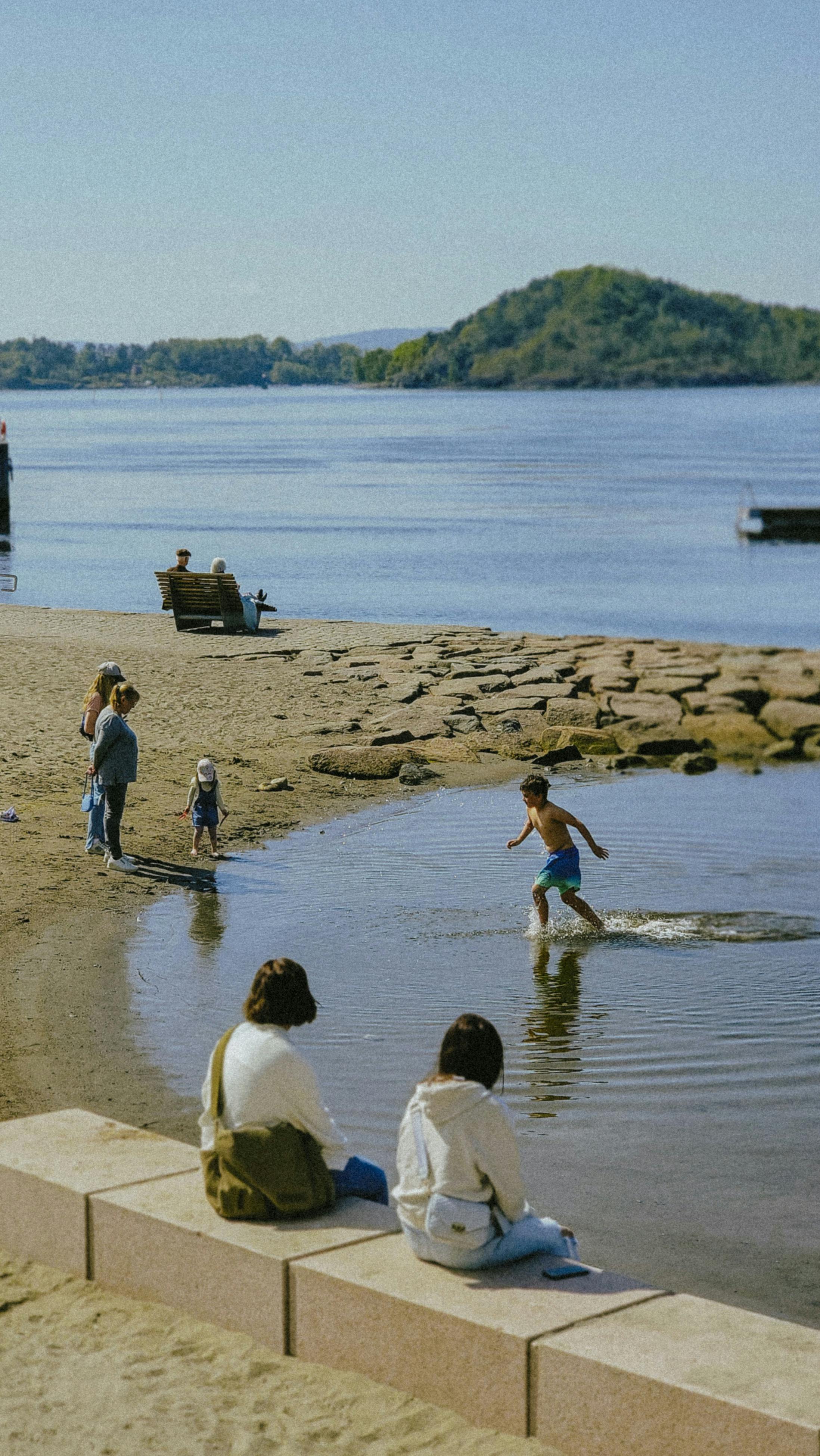 Families enjoying calm lagoon waters at Palawan Beach, Sentosa Island, Singapore