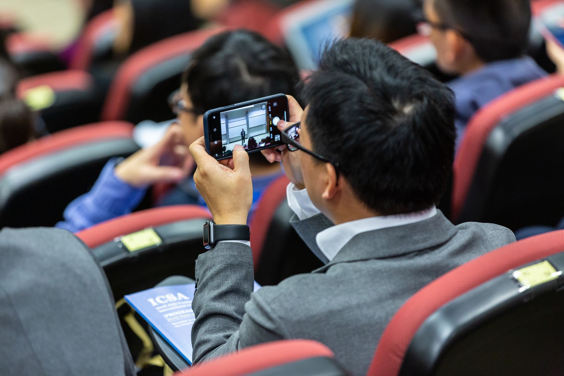 Person holding a smartphone to capture an event