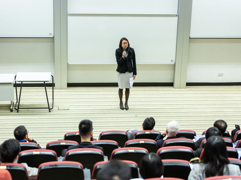 A speaker presenting to an audience in an auditorium