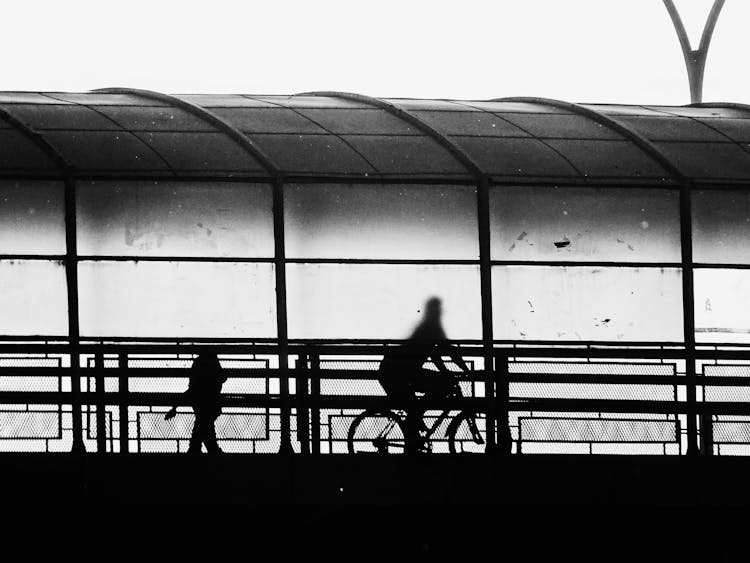 Silhouettes Of People Walking And Cycling In Tunnel