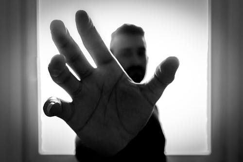 Grayscale Photo of Man Grabbing Using Right Hand