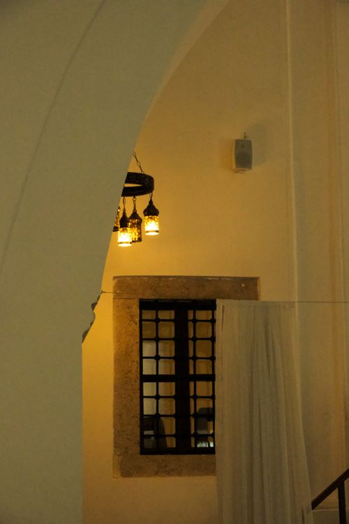 Free Cozy interior featuring hanging lanterns, curtains, and a window with warm lighting. Stock Photo