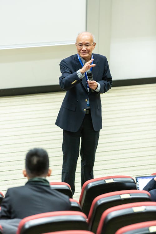 의자와 사람 앞에 서있는 남자