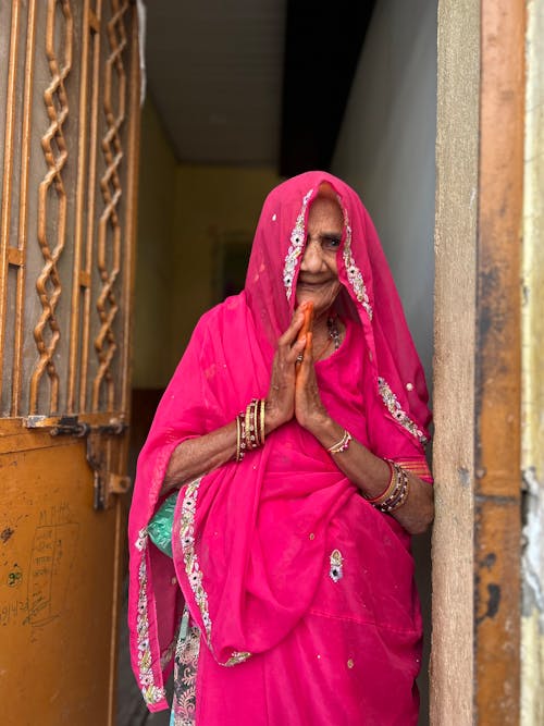 Elderly Woman in Traditional Clothing Standing in Doorway