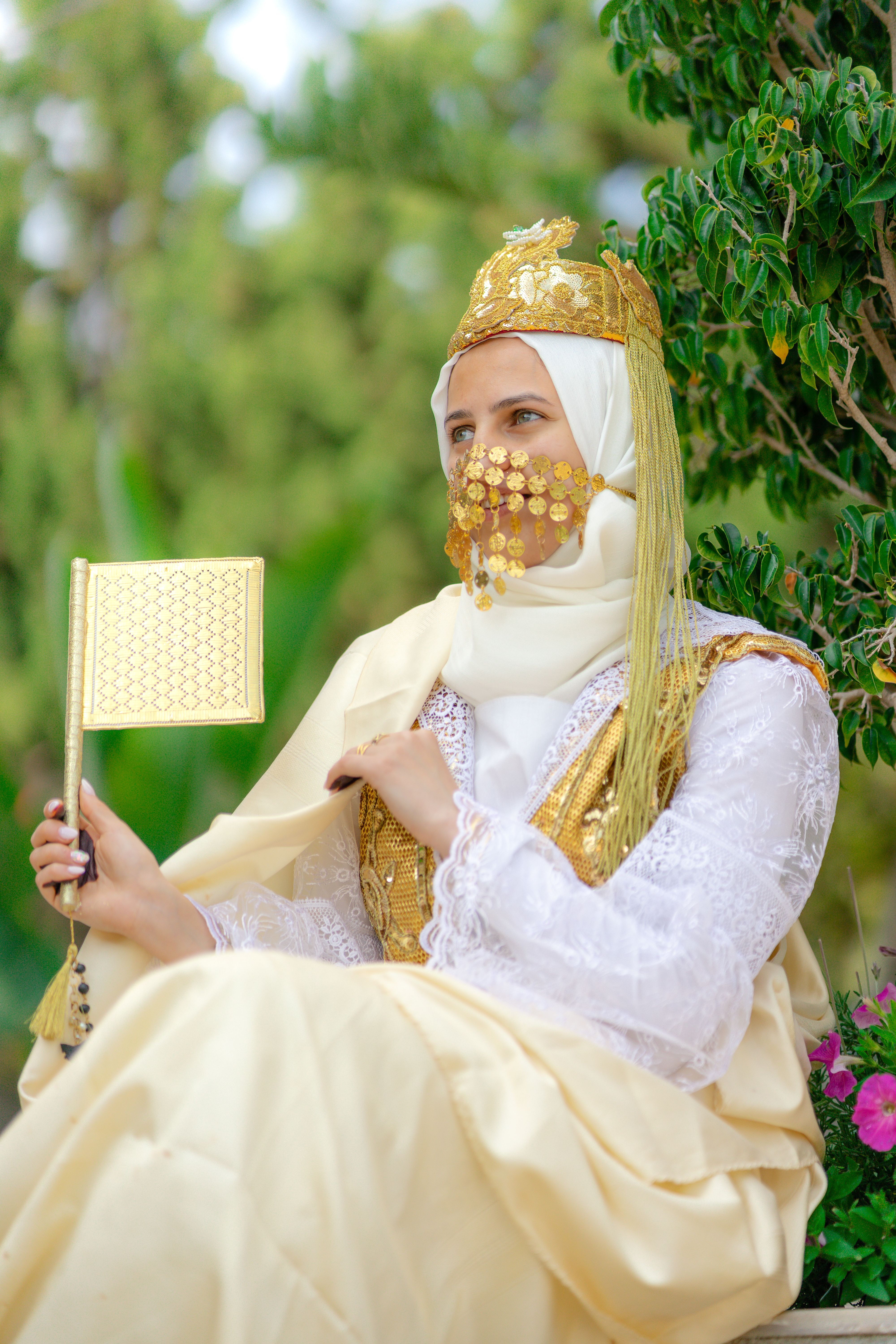 A woman in traditional Tunisian clothing sits outdoors, embodying cultural heritage and style.