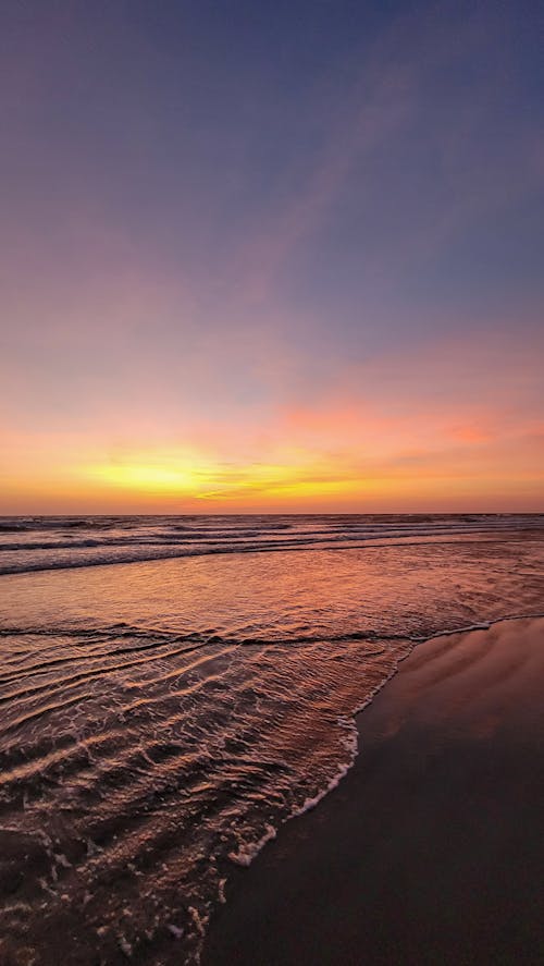 Golden Setting Sun Behind the Clouds Over the Ocean