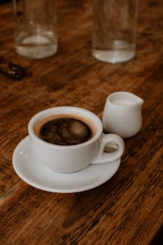 A warm coffee scene with espresso and cream on a wooden table in London.