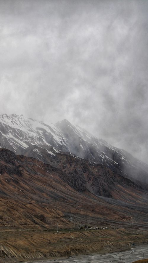 Free Dramatic landscape with mist-covered mountains and dense clouds above. Stock Photo