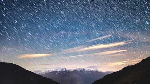 Free A breathtaking view of star trails over the snowy Alpine mountain range under a vibrant night sky. Stock Photo