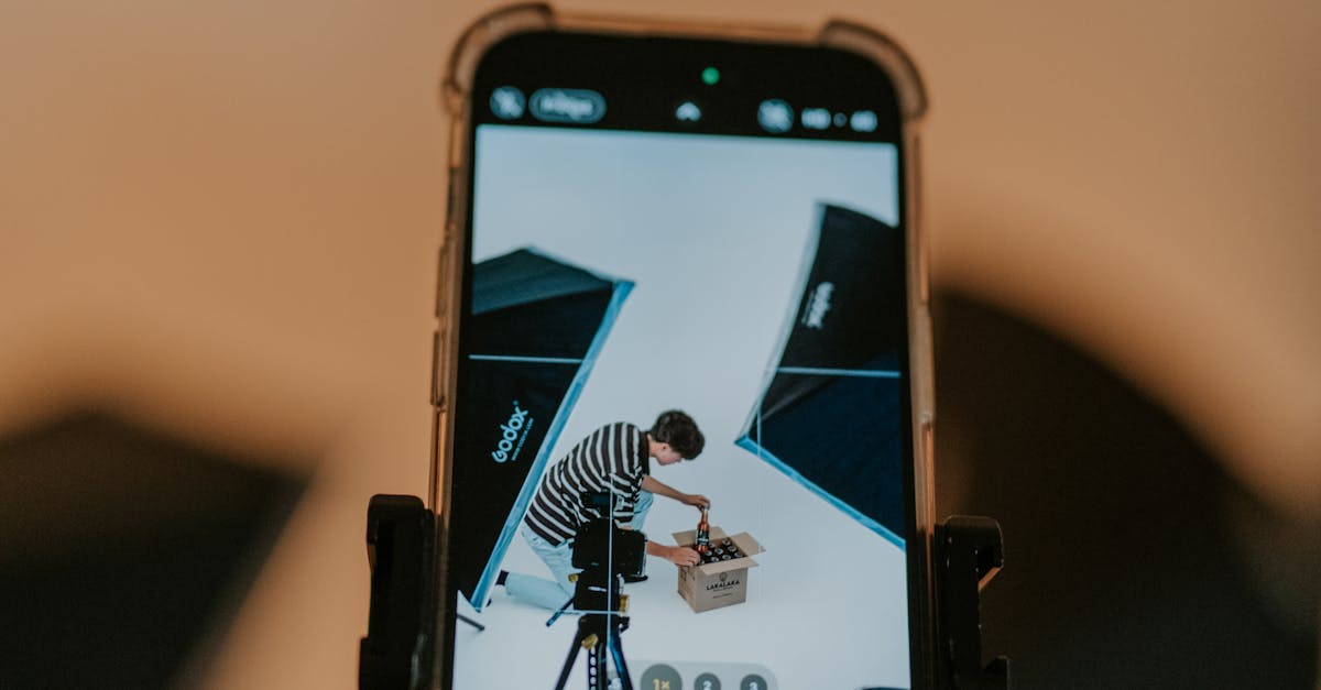 Close-up of a Smartphone Filming a Man in Studio Unboxing a Package
