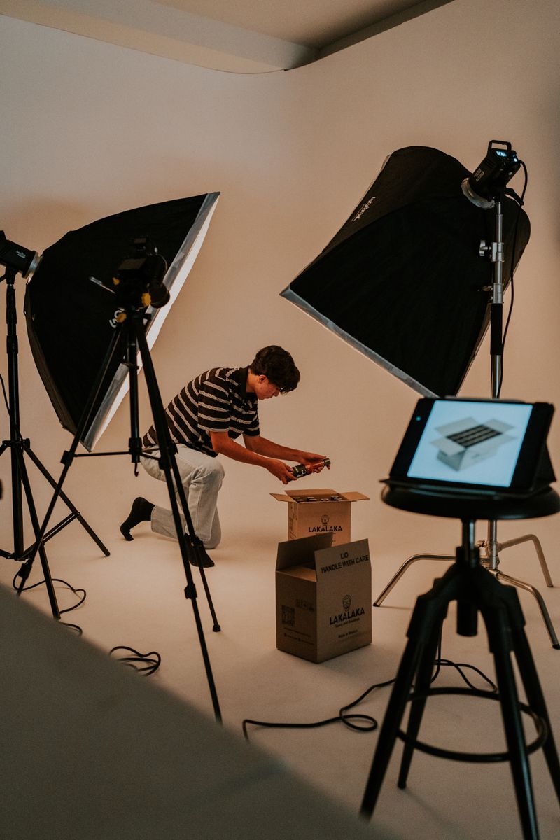 A man prepares an unboxing video in a professional studio with lights and tablet.