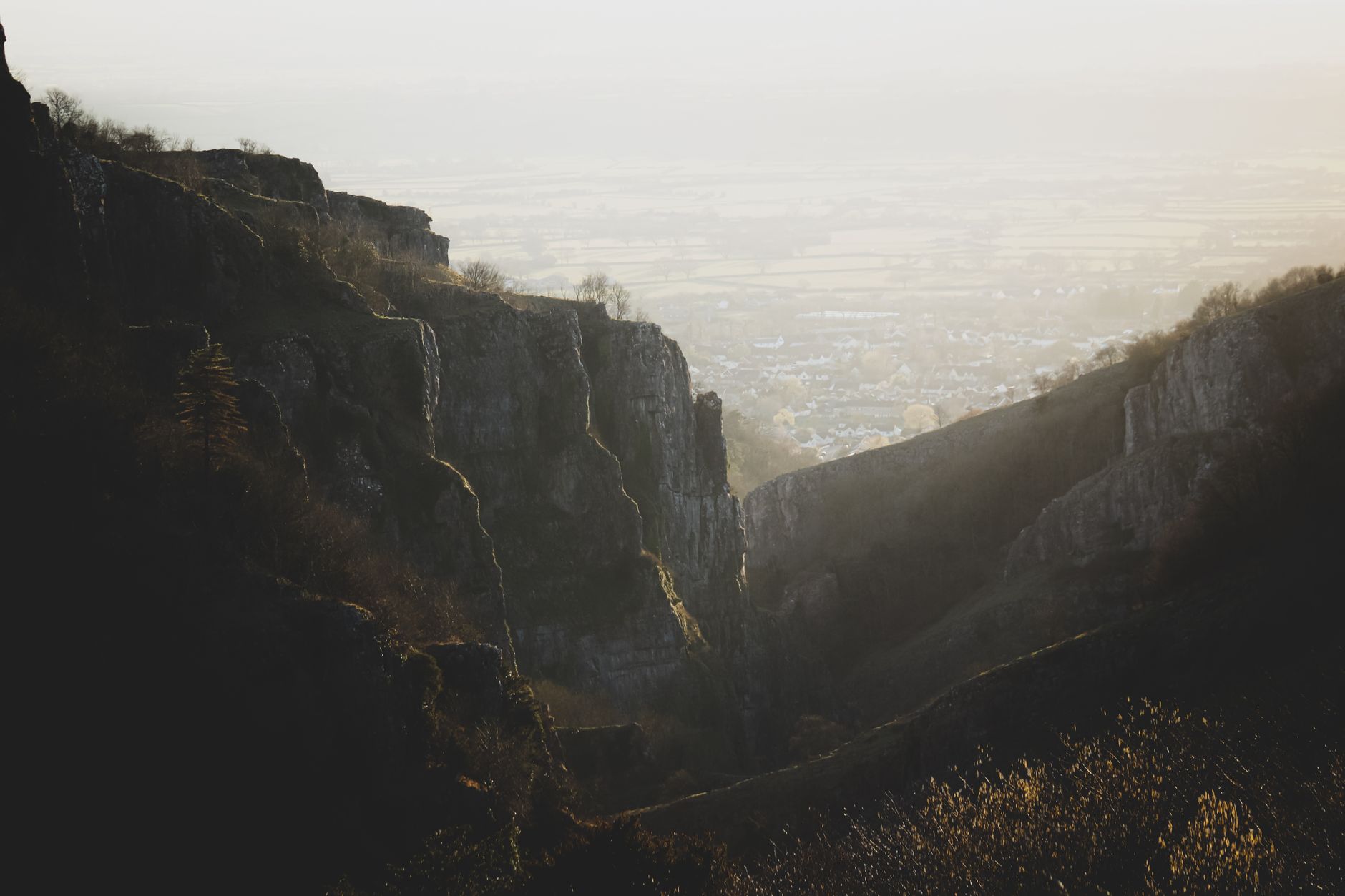 Cheddar Gorge limestone cliffs glowing in golden twilight mist, Somerset, England