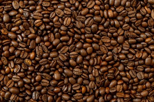 Free A detailed shot of dark roasted coffee beans piled together, showcasing their texture. Stock Photo