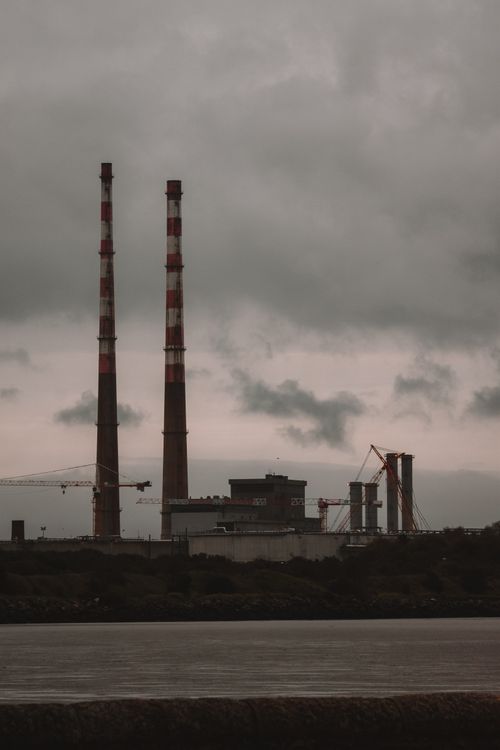 Free Moody industrial landscape with smokestacks under a cloudy sky. Stock Photo