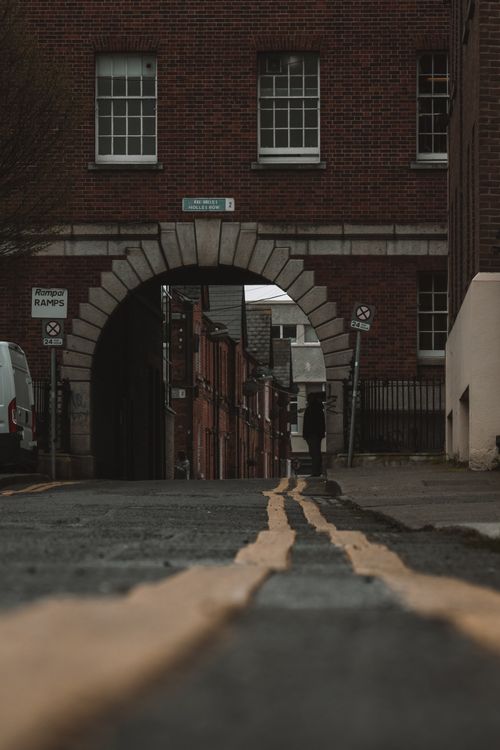 Free A low-angle shot of a brick archway on a street in Dublin, highlighting its Victorian architecture. Stock Photo
