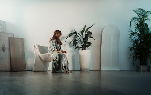 Woman Sitting near Plant in Room