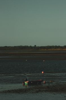 A tranquil scene of a boat and buoy on a calm lake at dusk, offering a peaceful ambiance.