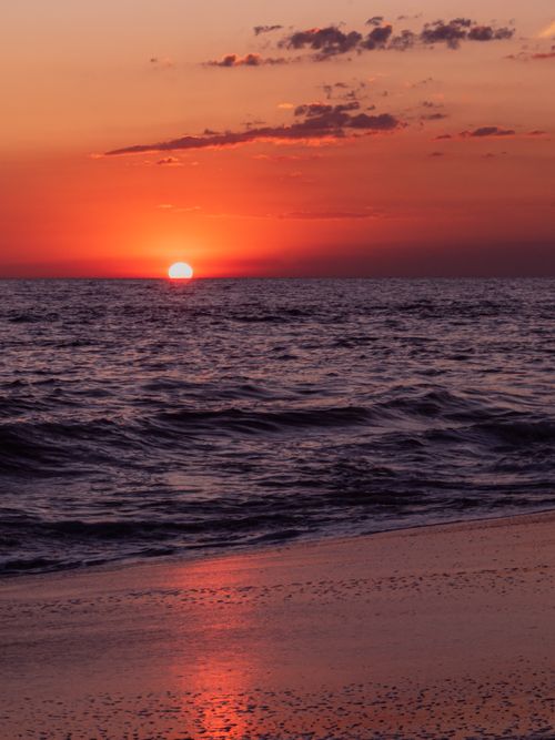 Free Experience the vibrant sunset over the ocean at Monterrico Beach, Guatemala, with vivid colors and tranquil waves. Stock Photo